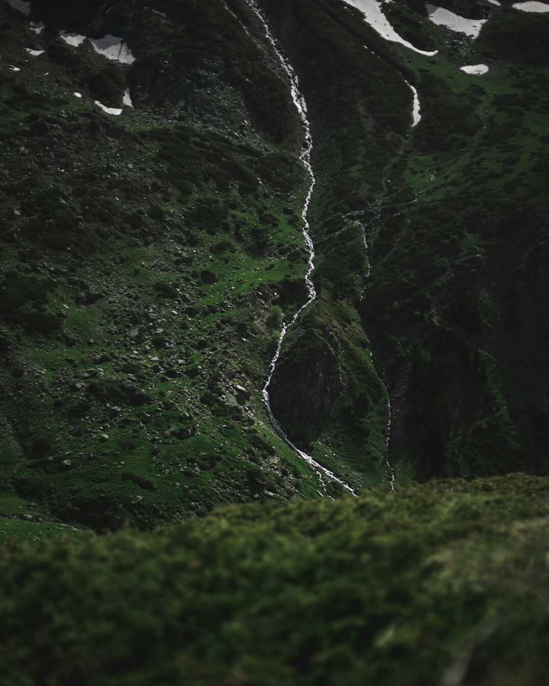 Waterfall flowing through a green valley