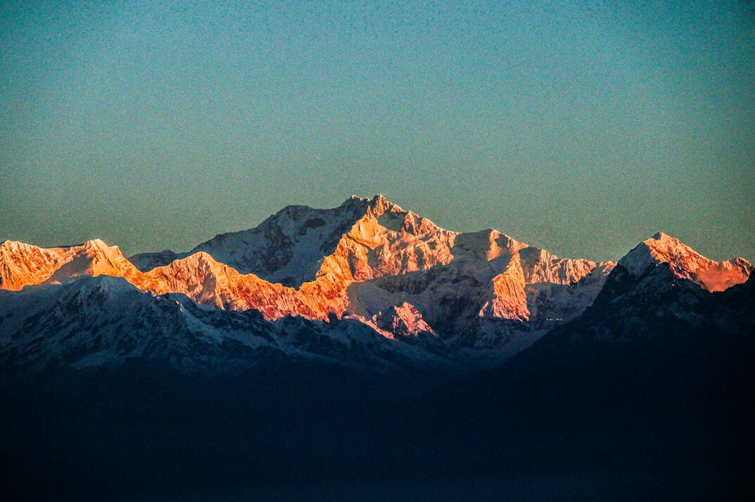 Snow capped mountain range under blue sky